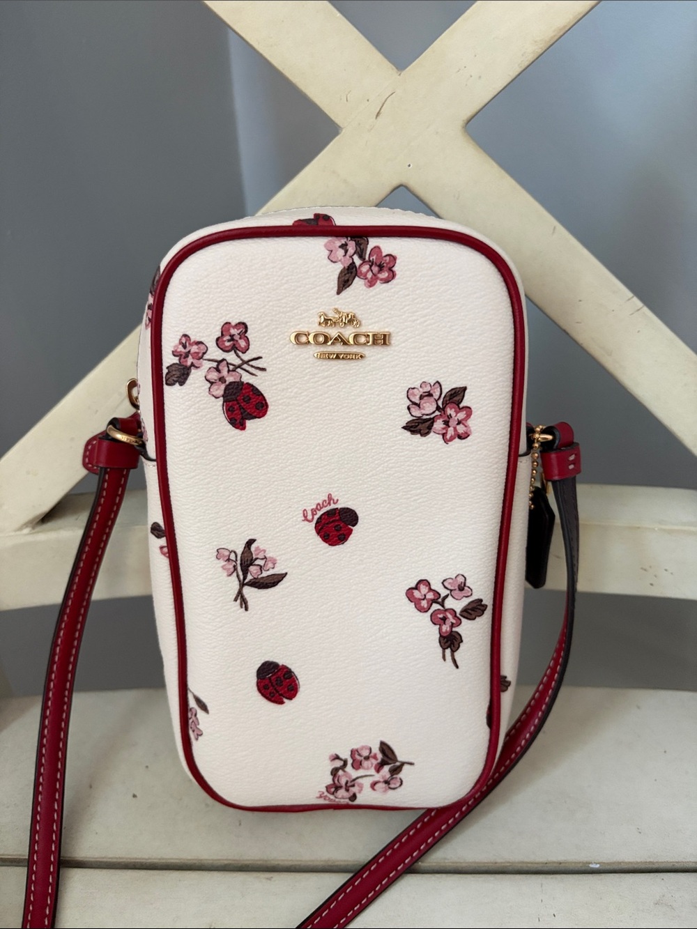 Coach White Pebbled Crossbody Phone Bag with Red Trim and Floral Accents